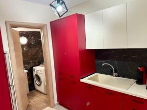 a red kitchen with a sink and a washing machine at Endless Blue Garden Villa in Paleo Tsifliki +95 photos