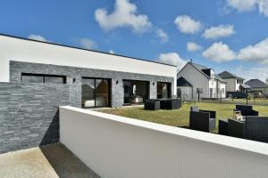 a modern house with a stone wall at Cosy Fréhel - Maison moderne proche du bourg in Frehel