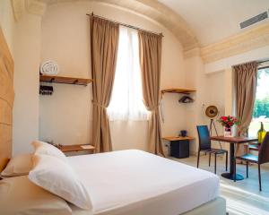 une chambre avec un lit, un bureau et une table dans l'établissement Masseria Le Lamie, à Villa Castelli