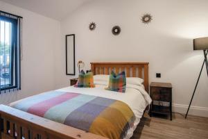 a bedroom with a bed with a colorful blanket at The Shed - 1 Bedroom - Cosheston in Cosheston