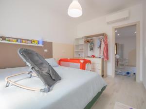 una camera da letto con un letto con un seggiolino per bambini sopra di Babyaccommodation Family Garden II a Pietra Ligure Altre 29 foto