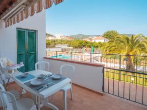 un tavolo bianco e sedie su un balcone con vista di Babyaccommodation Family Garden II a Pietra Ligure