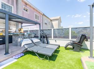 Apartment Merita في قشتيلا: وجود فناء على شواية وكراسي على العشب