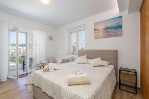 ドゥブロヴニクにあるApartment Milanelloの白いシーツが敷かれた大きなベッドのある寝室