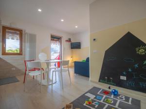 un soggiorno con tavolo, sedie e parete di Babyaccommodation Family Garden II a Pietra Ligure