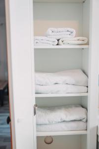 a closet filled with white towels on shelves at Bungalow Donaublick mit Pool und Garten in Sankt Nikola an der Donau