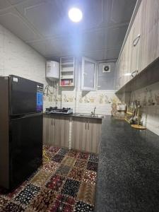 a kitchen with a black refrigerator and a tile floor at Family Friendly Apartment Kabul in Kabul
