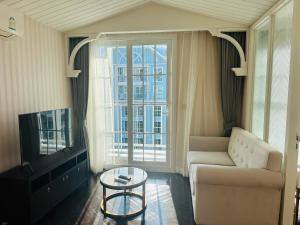 a living room with a couch and a tv and a table at Grand Florida Beach condo in Na Jomtien