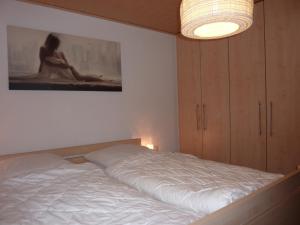 a bedroom with a bed and a painting on the wall at Ferienwohnung Im Lamer Winkel in Arrach