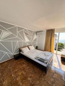 a bedroom with a bed with a geometric wall at Casa Roman II by the sea in Costinesti