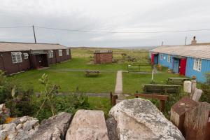 a group of houses in a field with rocks at Durness Youth Hostel in Durness