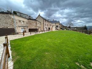 a large grass field next to some buildings at Le domaine du bez gite de Jules piscine,sauna,sauna,hammam,spa in Saint-Laurent-dʼOlt