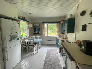 a kitchen with a table and a dining room at Villa Kurenniemi in Taipalsaari