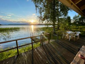 a dock with tables and chairs on a lake at Villa Kurenniemi in Taipalsaari