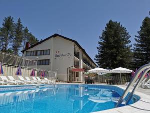 a hotel with a swimming pool in front of a building at Hotel Velista in Voneshta Voda