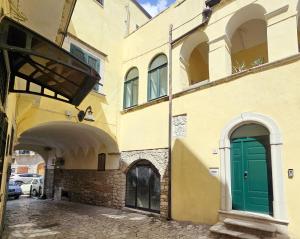 a building with a green door on a street at Domus Clara - guest house Venosa in Venosa