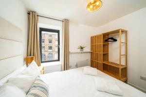 a bedroom with a white bed and a window at Castle Street Apartment in Dundee +11 photos
