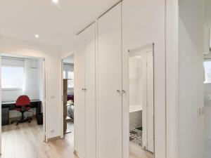 une pièce avec des murs blancs, un miroir et une chaise rouge dans l'établissement Chambre à 100m du Stade de France, à Saint-Denis