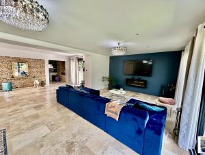 un salon avec un canapé bleu et une télévision dans l'établissement Chambre dans villa de standing, à Montaigut-sur-Save