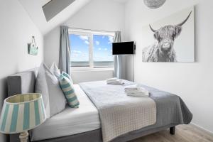 a bedroom with a bed and a picture of a cow at Ferienwohnung Große Freiheit Olpenitz in Olpenitz