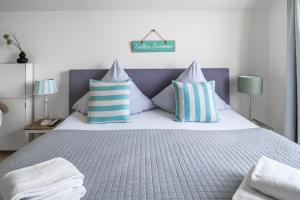 a bedroom with a bed with blue and white pillows at Ferienwohnung Große Freiheit Olpenitz in Olpenitz +30 photos