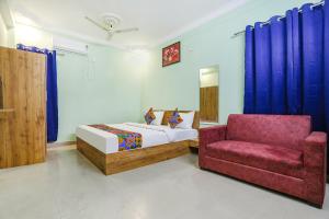 a bedroom with a bed and a red chair at FabHotel Sonnet Inns in Rānchī