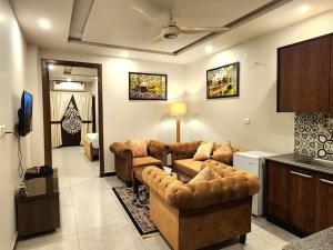 a living room with two couches and a television at Subtle 1Bed In Bahria Town in Rawalpindi