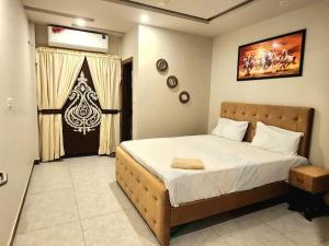 a bedroom with a large bed and a window at Subtle 1Bed In Bahria Town in Rawalpindi