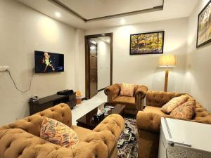 a living room with two couches and a tv at Subtle 1Bed In Bahria Town in Rawalpindi
