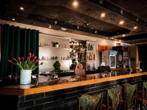 a bar with green curtains and a counter with chairs at Zajazd nad Zalewem Dzibice -Pensjonat, Agroturystyka in Dzibice