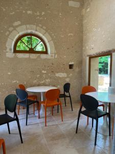 a room with tables and chairs and a window at Le Clos du Cèdre in Saint-Ouen