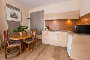 a kitchen with a wooden table and a table and chairs at Wiśniowy Sad in Kudowa-Zdrój +48 photos