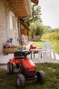 Un tractor de juguete sentado en el césped de un patio. en Vikendica Dar, en Begeč
