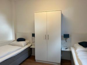 un armadietto bianco in una camera con 2 letti di Ferienwohnung am Hotel am Rathaus a Schönberg