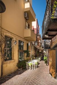 an alley with tables and chairs in a building at Palazzo di Irene in Chania