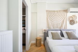 a white bedroom with a bed and a table at Glyfada Platinum Résidence in Athens