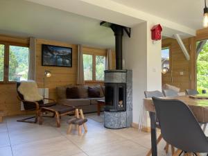 a living room with a fireplace and a table at Chalet rénové spacieux près des commerces, à 200m du village et du lac, navette ski-bus gratuite - FR-1-624-118 in Samoëns