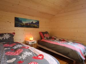 a bedroom with two beds in a log cabin at Chalet rénové spacieux près des commerces, à 200m du village et du lac, navette ski-bus gratuite - FR-1-624-118 in Samoëns