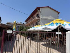 a fence with umbrellas in front of a building at Casa Roman II by the sea in Costinesti +7 photos