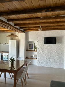 a dining room with a table and a stone wall at A Casa d Irene 2 in Kampos Paros