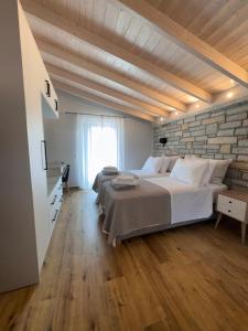 a bedroom with a large bed and a brick wall at Iris Villas Complex in Lefkada +95 photos