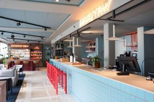 Un restaurante con un bar con sillas rojas. en Comfort Hotel Panorama, en Gotemburgo