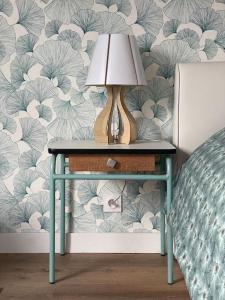 a table with a lamp on it next to a bed at Joli Studio en centre-ville in Vitré