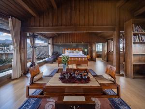a living room with a table and a bed at Jinli Chinese Courtyard Inn in Lijiang