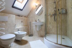 a bathroom with a toilet and a sink and a shower at Káli Borház - Nyaralóházak in Köveskál +81 photos