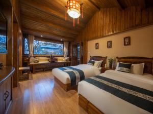 a bedroom with two beds and a couch in it at Jinli Chinese Courtyard Inn in Lijiang