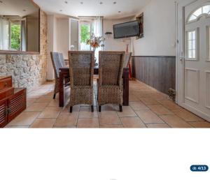 a dining room with a table and chairs and a television at Jolie maison in La Courneuve