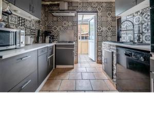 a large kitchen with a tile floor and appliances at Jolie maison in La Courneuve