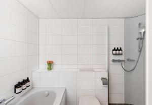 a white bathroom with a toilet and a shower at NH Noordwijk Conference Centre Leeuwenhorst in Noordwijkerhout