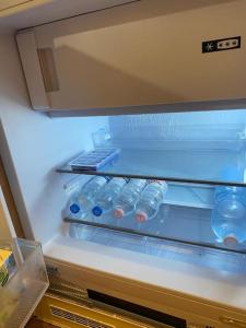 an open refrigerator with bottles of water in it at Duomo Prestige in Milan